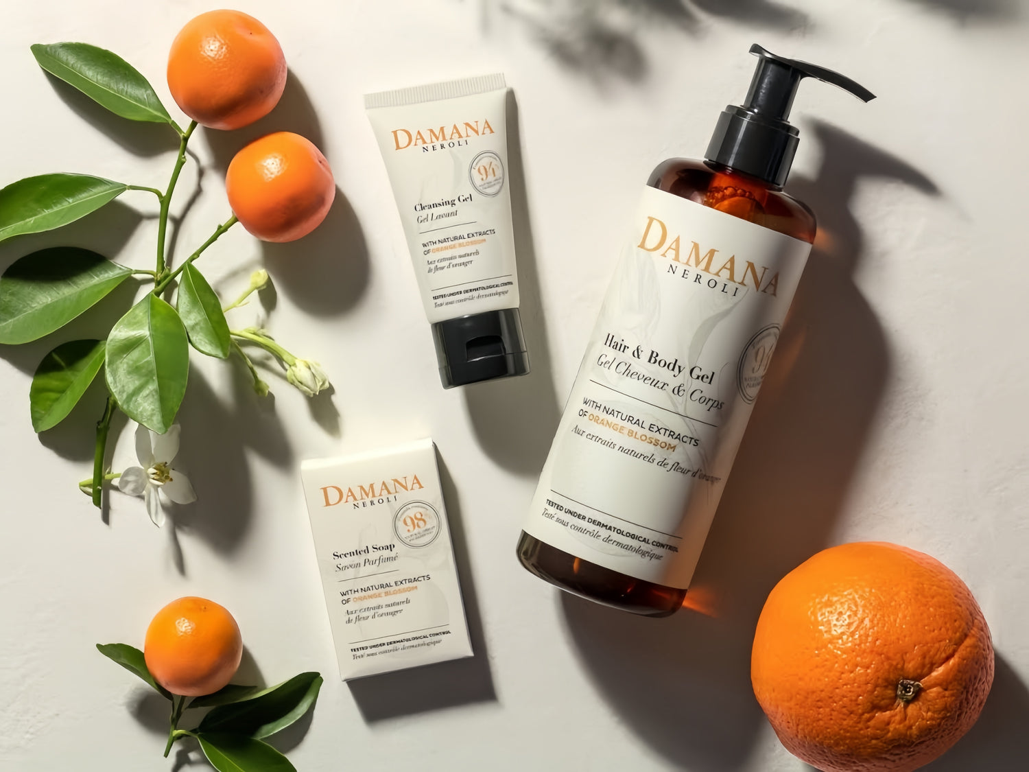 Three DAMANA NEROLI toiletries are displayed in the middle, a few oranges displayed next to them, looks very comfortable.