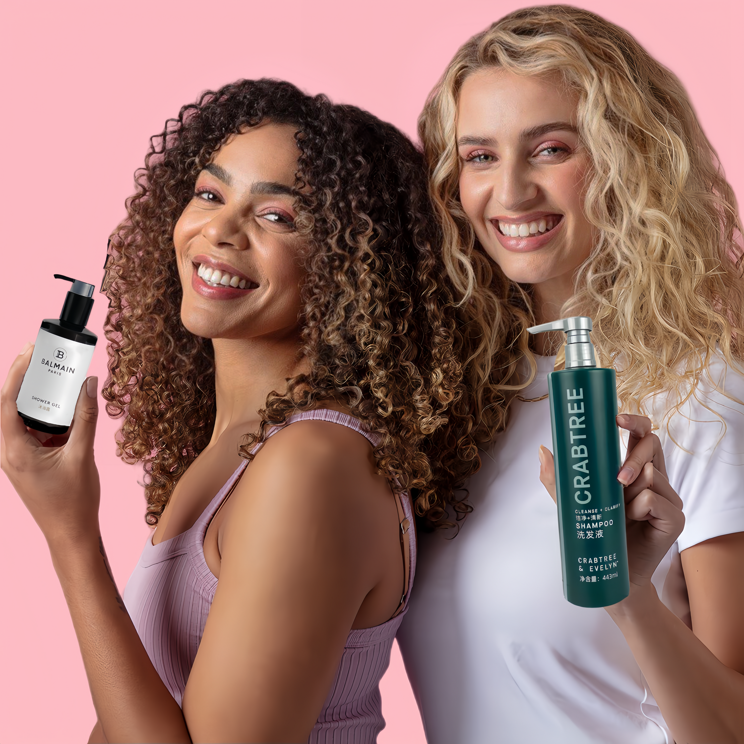 Two girls holding hotel toiletries on pink background, they are smiling happily.