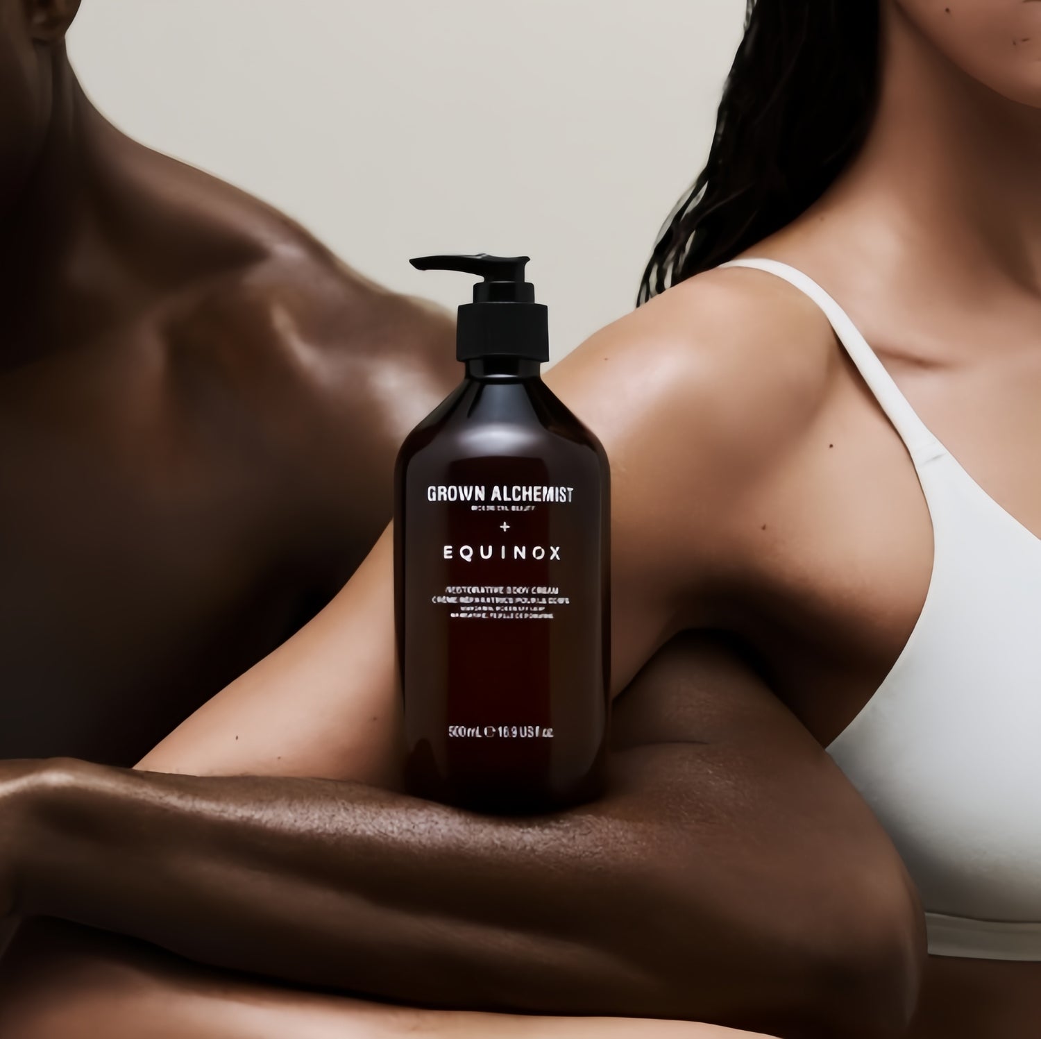 A man and a woman with their arms crossed, with a grown alchemist conditioner on top